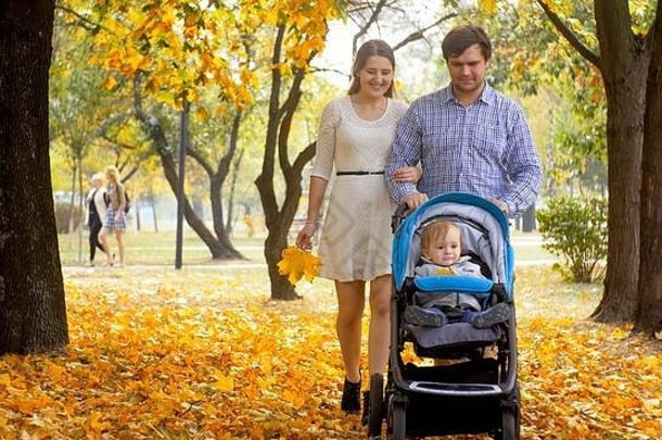 快乐微笑家庭婴儿婴儿车走秋天公园