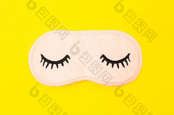 柔和的粉红色的睡眠面具关闭眼睛绣花睫毛明亮的黄色的霓虹灯背景时尚附件睡眠