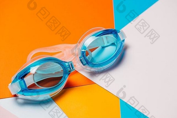 蓝色的游泳眼镜橡胶带橙色蓝色的几何背景产品概念