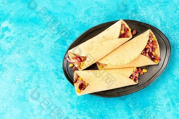 墨西哥卷饼三明治包装拍摄前蓝色的背景墨西哥玉米粉圆饼塞地面牛肉肉大米豆子洋葱辣椒辣椒