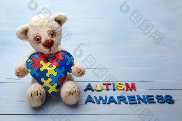 世界自闭症意识一天精神健康护理概念泰迪熊持有谜题拼图模式心