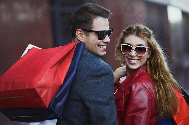 图片显示年轻的夫妇购物城市肖像夫妇购物袋城市人出售爱幸福概念