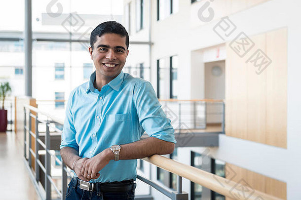 自信年轻的男人。站办公室建筑蓝色的衬衫