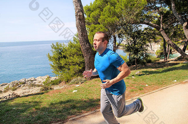 适合年轻的男人。慢跑运行小道海滨休闲健身运动员运动服装享受物理活动夏天一天