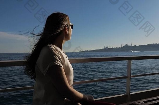 快乐女人太阳镜挥舞着头发旅行船享受华丽的海景阳光特写镜头
