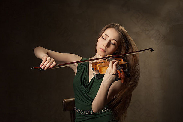 美丽的年轻的女人玩小提琴黑色的背景