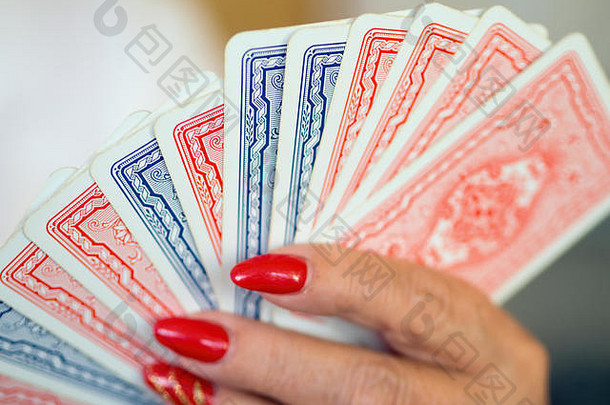 玩卡片蓝色的红色的设计回来排女手红色的漆指甲焦点点休息光bookeh特写镜头