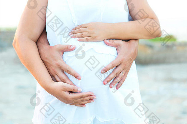 男人。年轻的怀孕了女人拥抱在户外家庭分娩概念