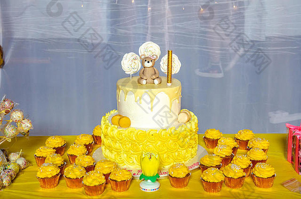 层生日蛋糕包围黄色的纸杯蛋糕表格