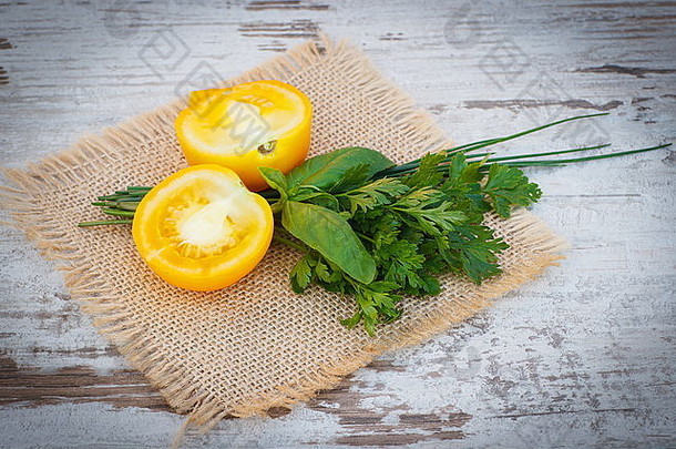 新鲜的黄色的番茄新鲜的绿色欧芹罗勒黄麻帆布白色木表格花园阳光明媚的一天健康的