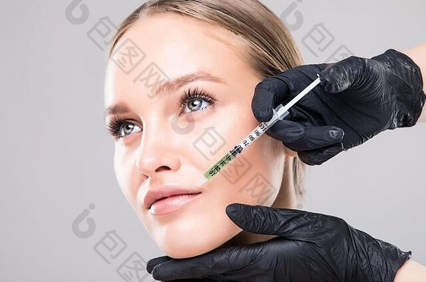年轻的女人脸接收复兴治疗医生手手套提升胶原蛋白唇区域