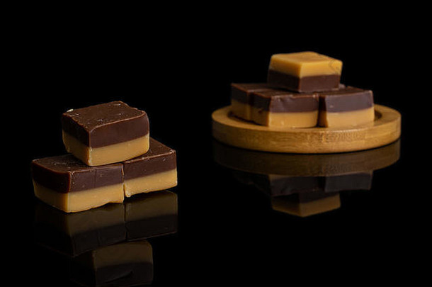集团甜蜜的棕色（的）焦糖巧克力糖果竹子过山车孤立的黑色的玻璃
