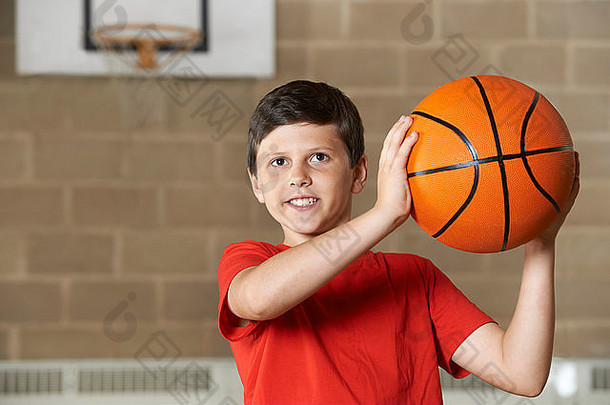 男孩拍摄篮球匹配学校健身房