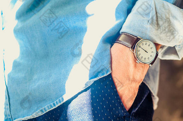 关闭男人的附件优雅的手腕手表手口袋里滚衬衫袖子非正式的休闲穿概念