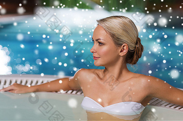 快乐女人坐着极可意水流按摩浴缸在游泳池边