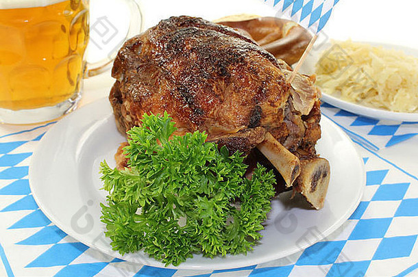 新鲜的巴伐利亚烤猪肉关节椒盐卷饼啤酒酸菜光背景