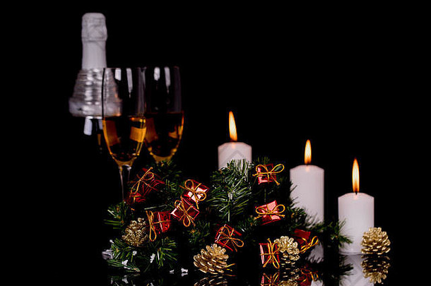 酒眼镜香槟瓶蜡烛圣诞节饰品黑色的背景反射复制空间快乐圣诞节快乐