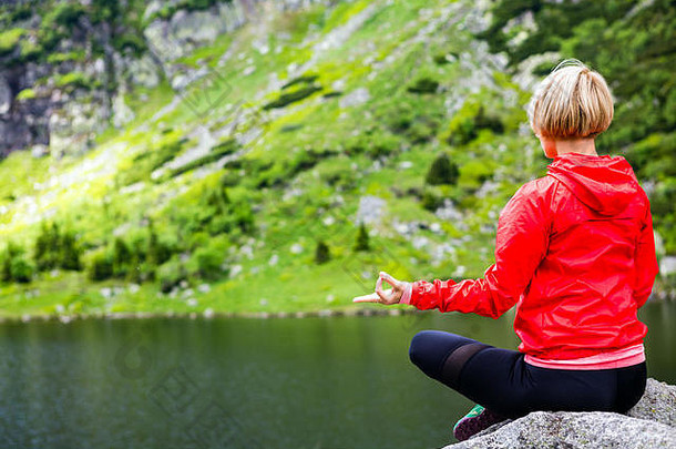 女人冥想瑜伽构成前面山湖女徒步旅行者放松美丽的鼓舞人心的山景观健康的生活方式超越