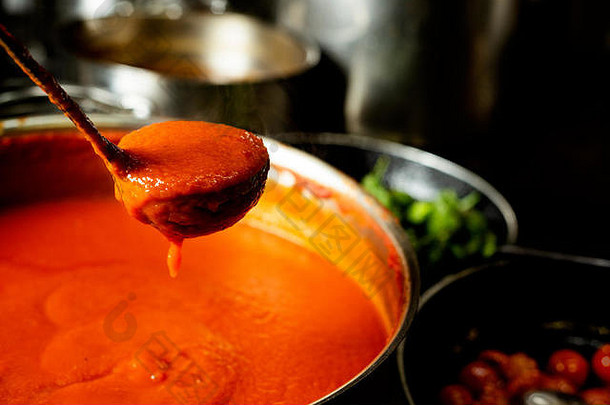 特写镜头平底锅番茄酱汁煎锅煮熟的樱桃西红柿绿色辣椒专业厨房