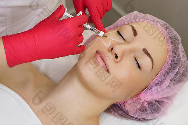 手美容师特写镜头注入透明质酸酸脸颊区域女孩化妆品过程水疗中心沙龙平滑模仿皱纹