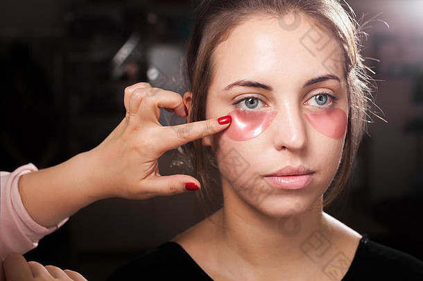 化妆艺术家应用水凝胶眼睛补丁女人