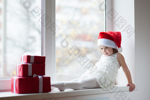 漂亮的女孩圣诞老人他坐着窗口盒子礼物
