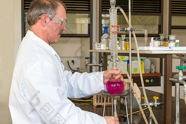 高加索人化学老师加热destillates粉红色的流体实验室