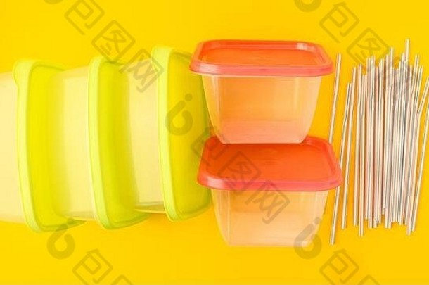 塑料午餐盒子喝吸管黄色的背景色彩斑斓的塑料容器