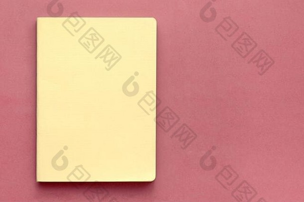 前视图关闭黄色的封面笔记本粉红色的桌子上背景业务概念前视图平躺复制空间