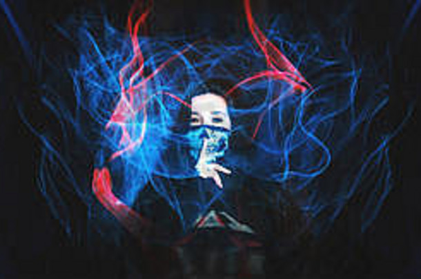 女孩穿头骨面具手指口沉默黑暗背景红色的蓝色的火焰使光绘画技术