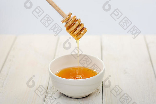 蜂蜜勺子碗填满花蜂蜜
