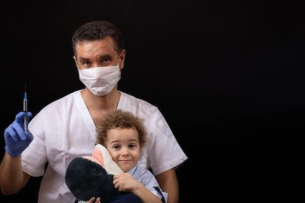 医生医疗面具手套耐心地解释孩子疫苗