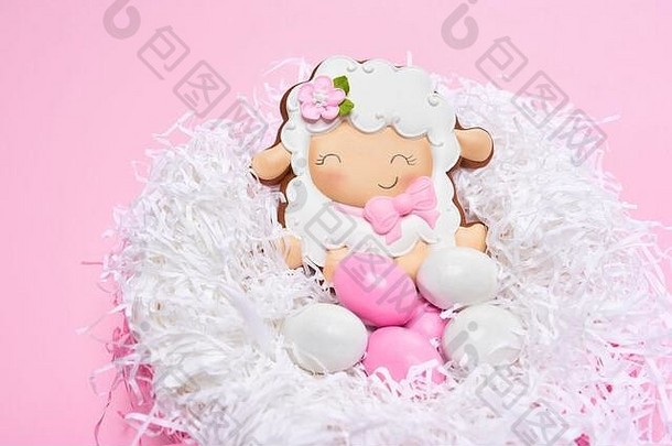 视图上釉饼干形状可爱的羊说谎色彩斑斓的鸡蛋白色巢孤立的粉红色的背景关闭可爱的糕点春天复活节假期概念