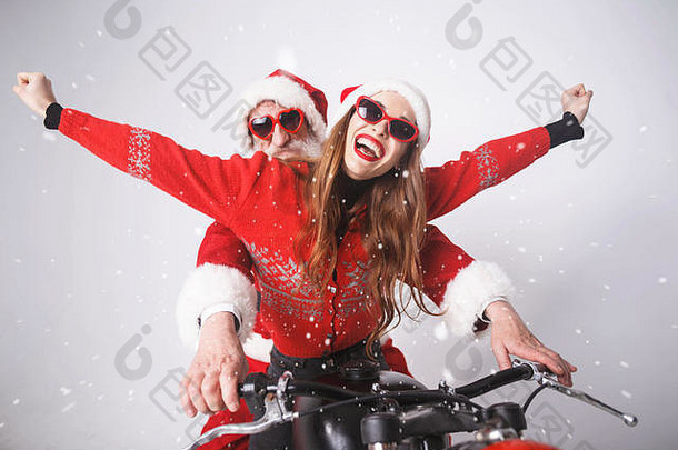 快乐年轻的夫人老人穿圣诞老人他红色的毛衣太阳镜笑坐着圣诞老人老人摩托车一年圣诞节假期记忆礼物购物折扣商店雪少女圣诞老人老人化妆发型狂欢节