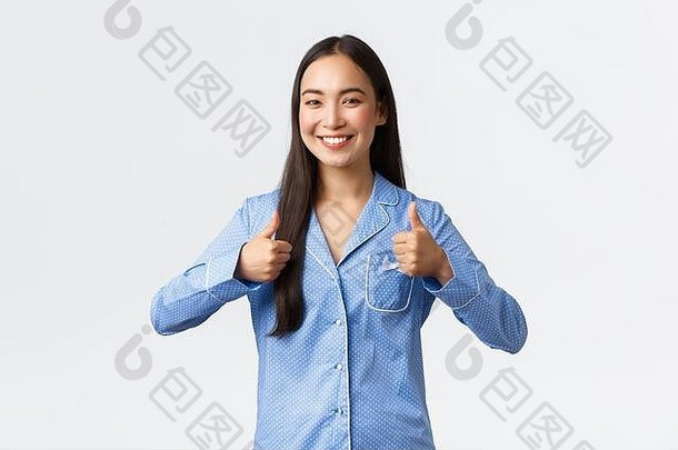 乐观的快乐微笑亚洲女孩蓝色的睡衣满意显示竖起大拇指批准好工作站很高兴