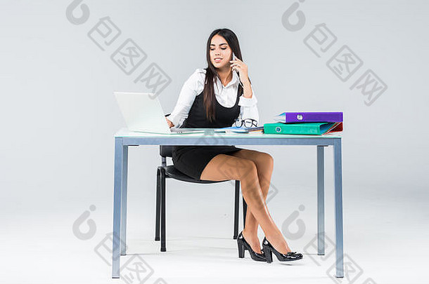 美丽的微笑女人坐在表格工作移动PC白色衬衫孤立的白色
