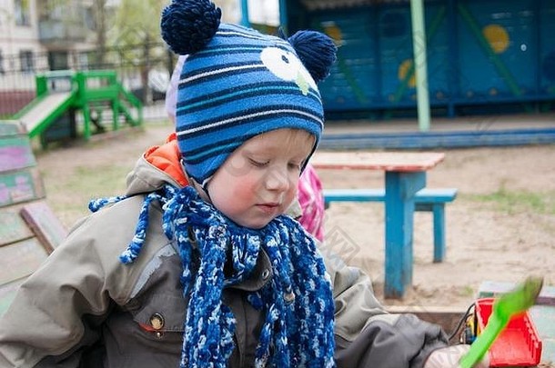 特写镜头肖像男孩年很酷的春天阳光明媚的一天玩沙盒幼儿园显示各种情绪玩具春天凉爽温暖的衣服