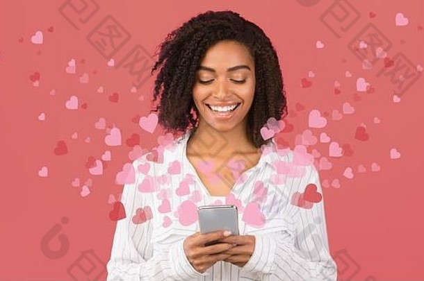 非洲美国女人browsign社会媒体移动电话心飞行粉红色的背景