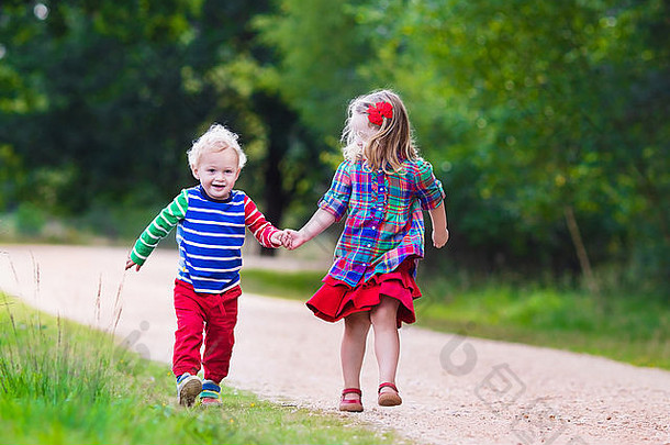 孩子们玩秋天公园孩子们玩在户外阳光明媚的秋天一天男孩女孩运行手手森林