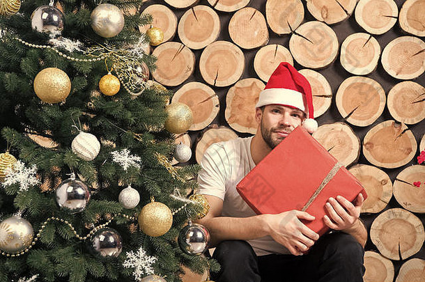 男子气概红色的他持有礼物木日志圣诞老人男人。盒子圣诞节树拳击一天概念圣诞节一年礼物准备冬天假期庆祝活动