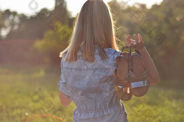女孩持有夏天凉鞋回来自然夏天阳光明媚的一天散景模糊软影子图像效果形式太阳雷相机镜头