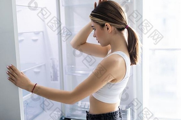 一边视图年轻的女人食物冰箱