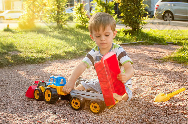 肖像可爱的年蹒跚学步的男孩玩玩具卡车预告片操场上公园孩子挖掘建筑沙子