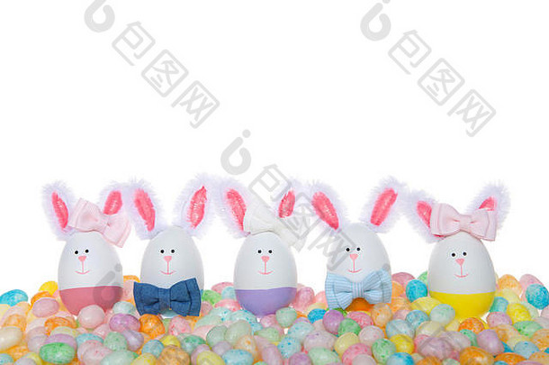 复活节鸡蛋精心制作小兔子男孩女孩穿弓关系弓耳朵坐着柔和的彩色的斑点果冻豆子孤立的白色