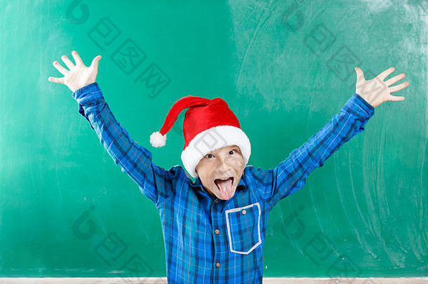 小男孩穿圣诞老人他有趣的黑板上