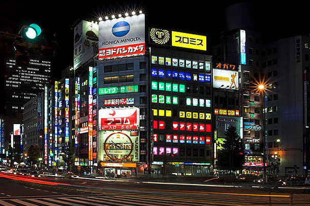 行人穿越新宿东京晚上明亮的灯交通模糊