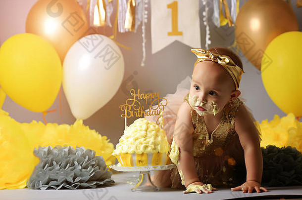 婴儿生日一年女孩破碎黄色的蛋糕