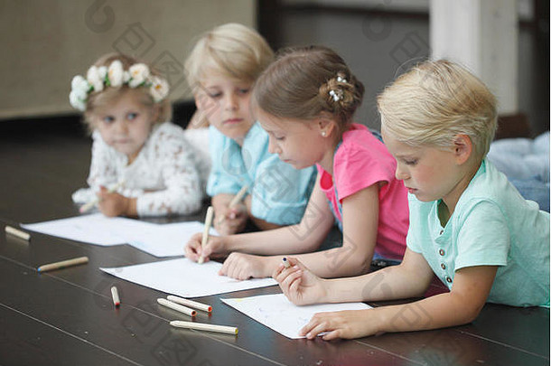 集团可爱的孩子们画色彩斑斓的铅笔地板上