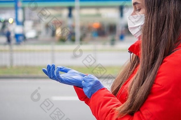 年轻的女人把保护手套电晕病毒概念年轻的成人女孩一边配置文件穿医疗脸面具手套coron
