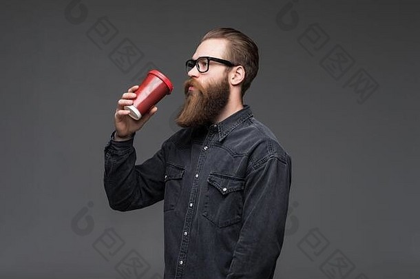 英俊的有胡子的男人。头发胡子胡子脸衬衫持有白色杯杯子喝茶咖啡